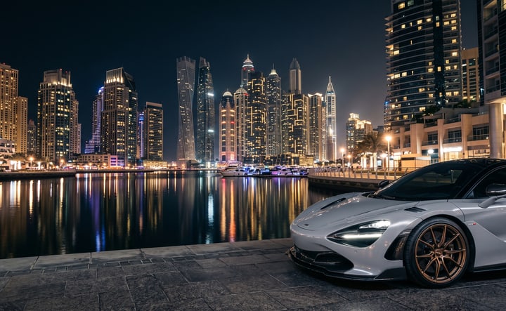 A supercar in a satin Nardo grey wrap at Dubai Marina at night, the kind of render a wrap shop hands a customer